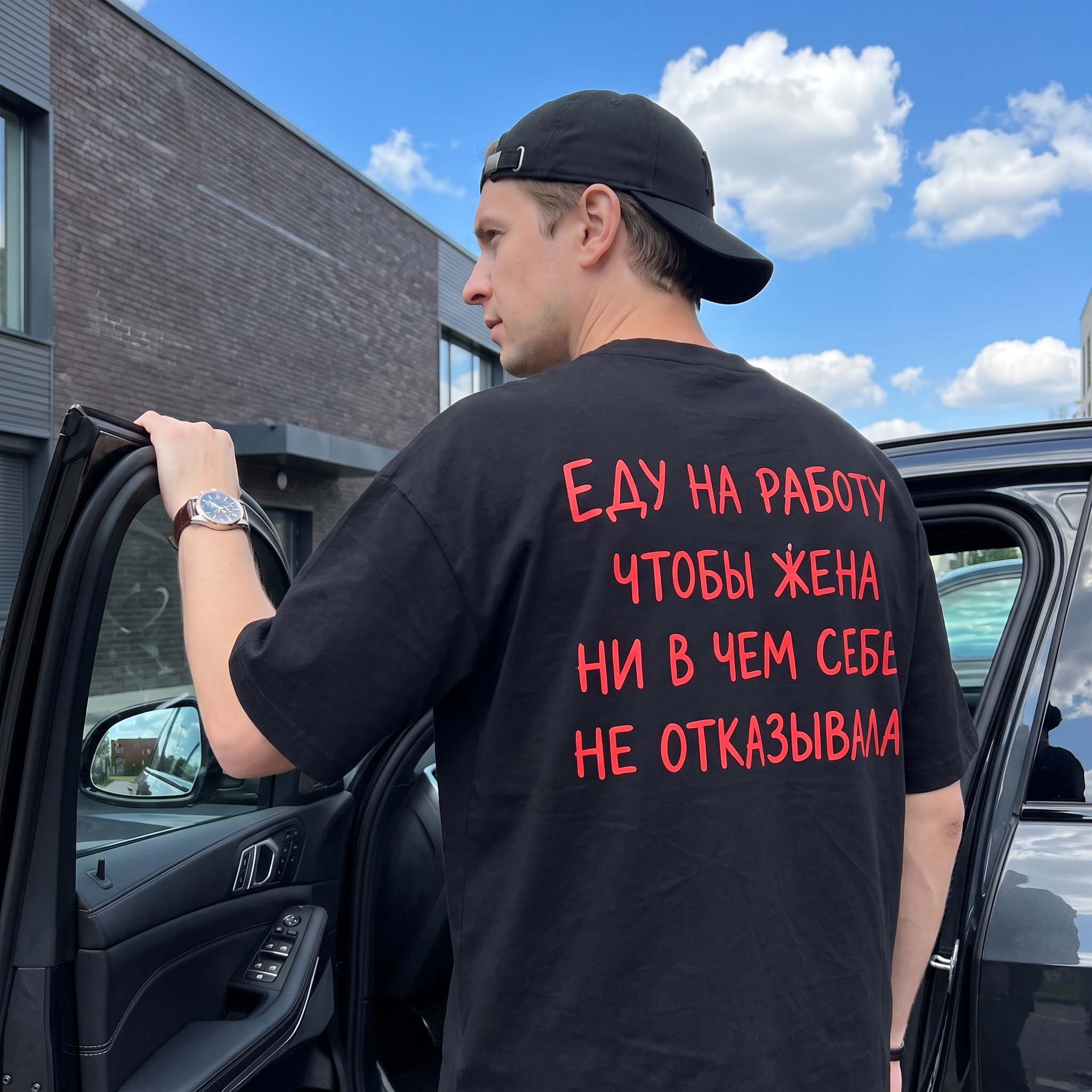 Мужчина у машины со смыслом на спине