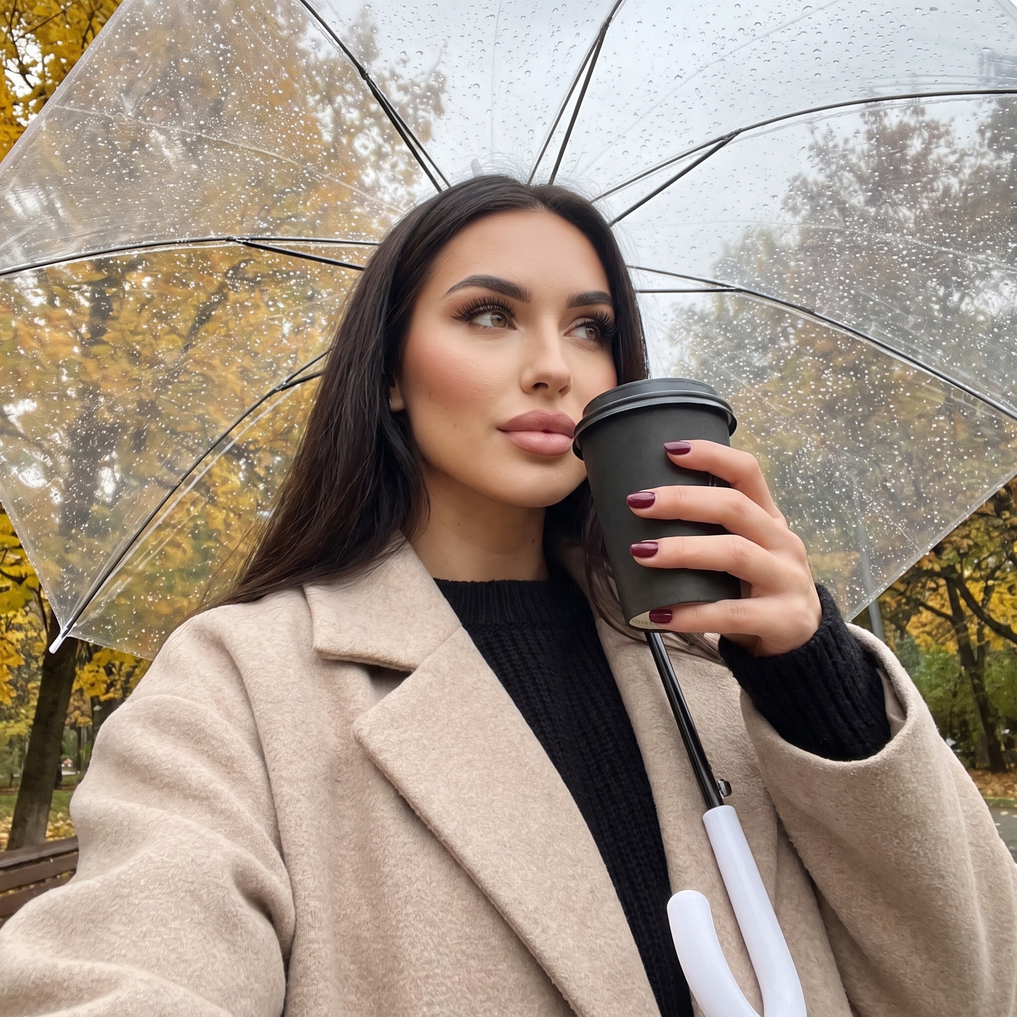 Девушка под зонтом с кофе осенью